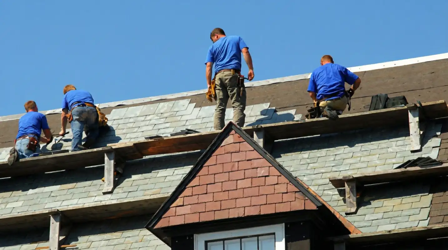 Roof replacement in progress with a team of professional contractors installing new shingles on a residential home in Rockford, IL